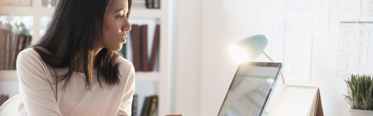 Ambiente de escritório com uma mulher olhando para o notebook